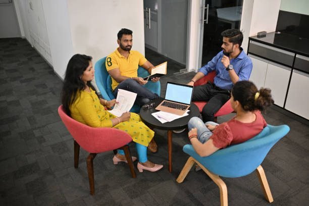 A scene where four colleagues are discussing something.