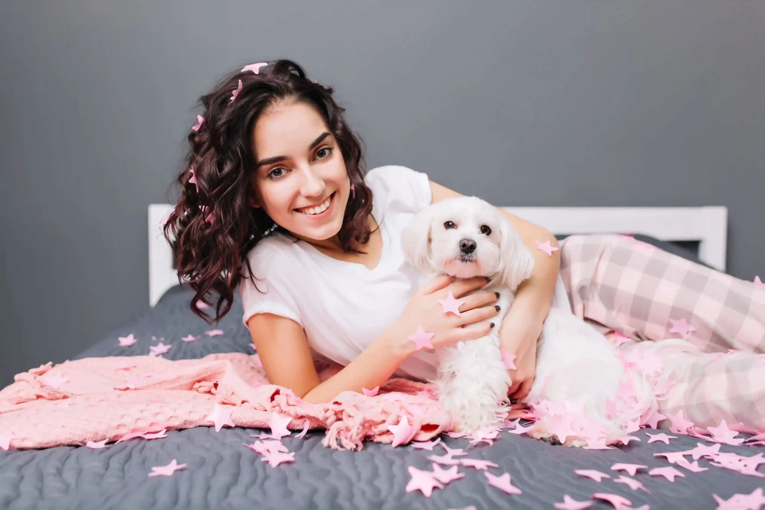 Happy smiling girl, laying down with her cute puppy female dog